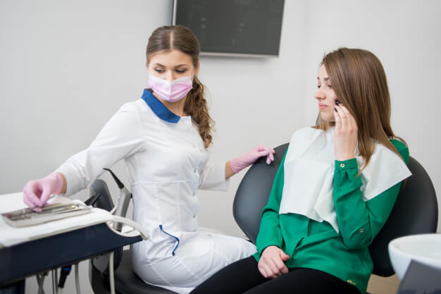 Dentista examinando paciente: como é feito a cirurgia maxilar?