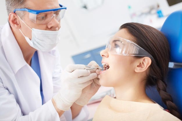 raiz do dente exposta dentista atendendo paciente