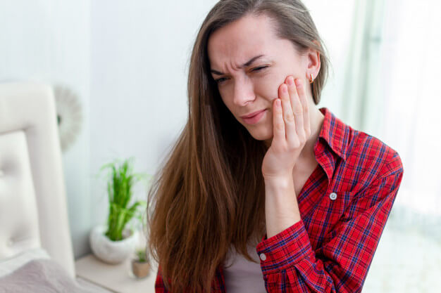 raiz do dente exposta mulher com dor de dente