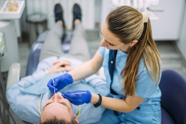raiz do dente exposta paciente e dentista no procedimento odontologico