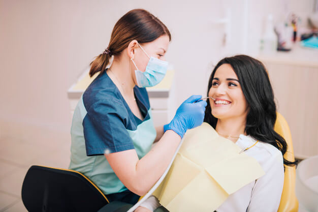 limpeza dentária dentista atendendo paciente que esta sorrindo